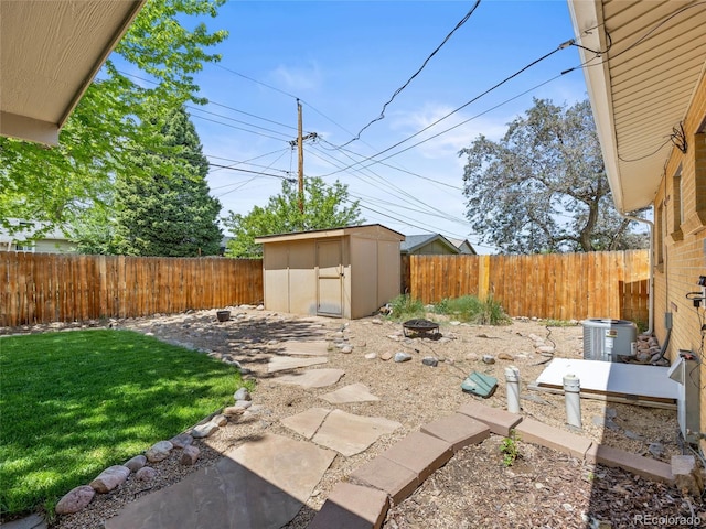 view of patio featuring a storage shed, an outbuilding, cooling unit, and an outdoor fire pit