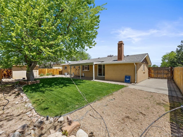 back of house with a patio area, brick siding, a chimney, a storage shed, and an outdoor structure