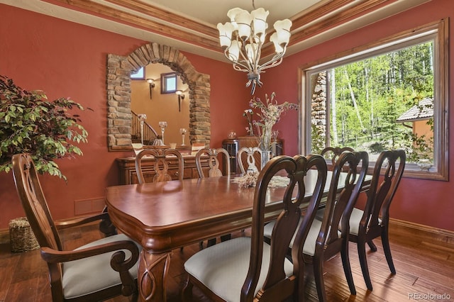 dining space featuring a tray ceiling, a chandelier, hardwood / wood-style flooring, and crown molding