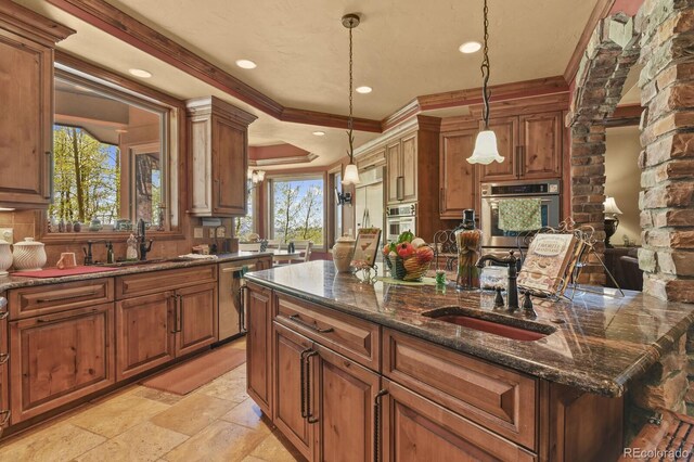 kitchen featuring ornamental molding, dark stone countertops, sink, light tile floors, and pendant lighting