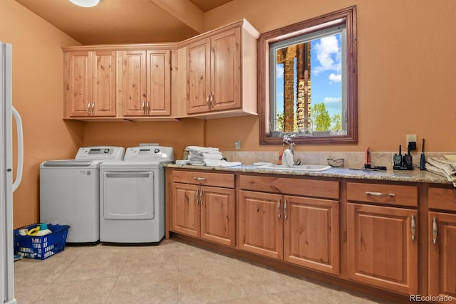 laundry room with sink, washer and dryer, cabinets, and light tile floors