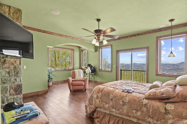 bedroom with dark wood-type flooring, ceiling fan, access to exterior, and crown molding