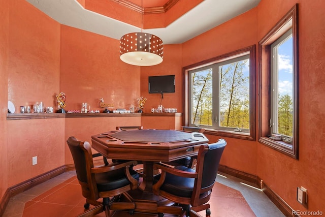 tiled dining area with a raised ceiling