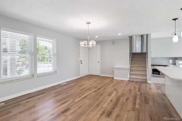 9442 W Walden Ave, Littleton, CO 80128 - unfurnished dining area featuring light wood-type flooring, a chandelier, recessed lighting, and stairs