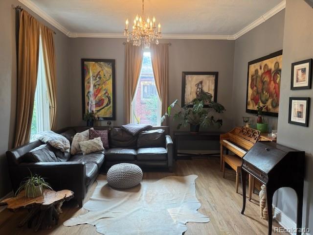 3098 W 39th Ave, Denver, CO 80211 - living area featuring wood finished floors, healthy amount of natural light, a chandelier, and ornamental molding