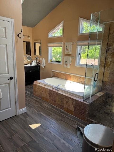3098 W 39th Ave, Denver, CO 80211 - full bathroom with vanity, vaulted ceiling, a shower stall, and a garden tub