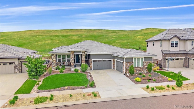 9433 Torrey Way, Arvada, CO 80007 - view of front of property featuring stone siding, driveway, an attached garage, and a tiled roof