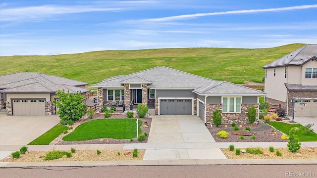 9433 Torrey Way, Arvada, CO 80007 - view of front of property with stone siding, driveway, an attached garage, and a front lawn