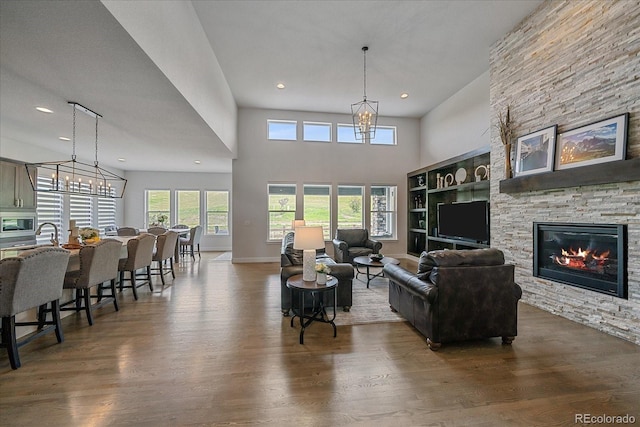 9433 Torrey Way, Arvada, CO 80007 - living area with wood finished floors, a chandelier, a fireplace, recessed lighting, and a high ceiling