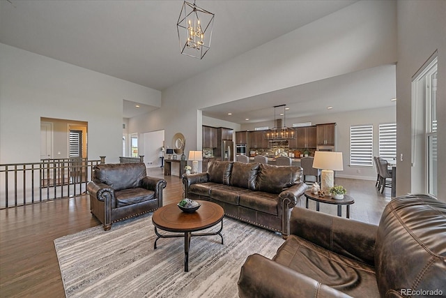 9433 Torrey Way, Arvada, CO 80007 - living room featuring a chandelier, wood finished floors, a high ceiling, baseboards, and recessed lighting