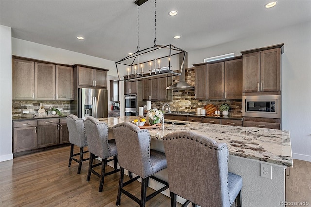 9433 Torrey Way, Arvada, CO 80007 - kitchen featuring appliances with stainless steel finishes, a sink, decorative backsplash, dark wood-type flooring, and dark brown cabinetry
