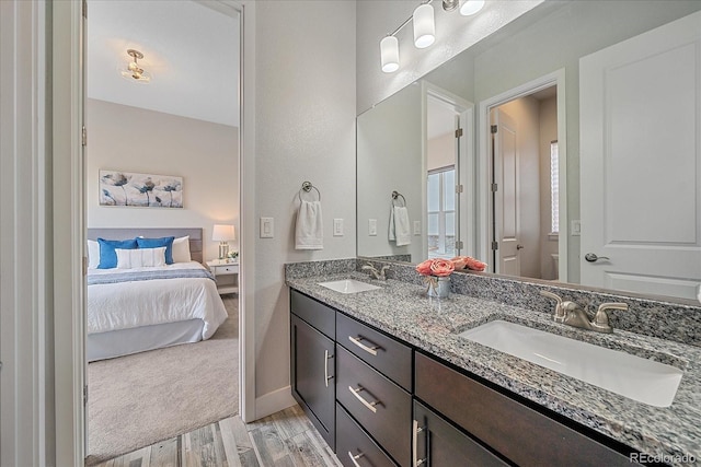 9433 Torrey Way, Arvada, CO 80007 - ensuite bathroom featuring wood finished floors, double vanity, toilet, and baseboards