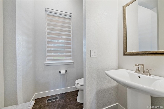 9433 Torrey Way, Arvada, CO 80007 - bathroom with toilet, baseboards, and a sink