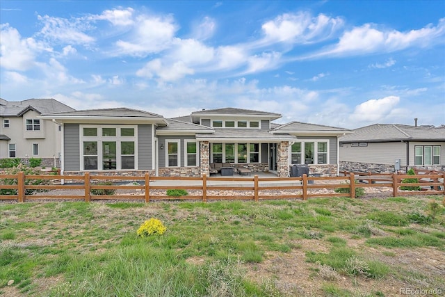 9433 Torrey Way, Arvada, CO 80007 - rear view of property featuring a patio area, a fenced backyard, and stone siding