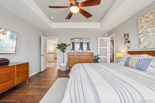 5362 E 140th Pl, Thornton, CO 80602 - bedroom with visible vents, baseboards, dark wood-type flooring, a raised ceiling, and a ceiling fan
