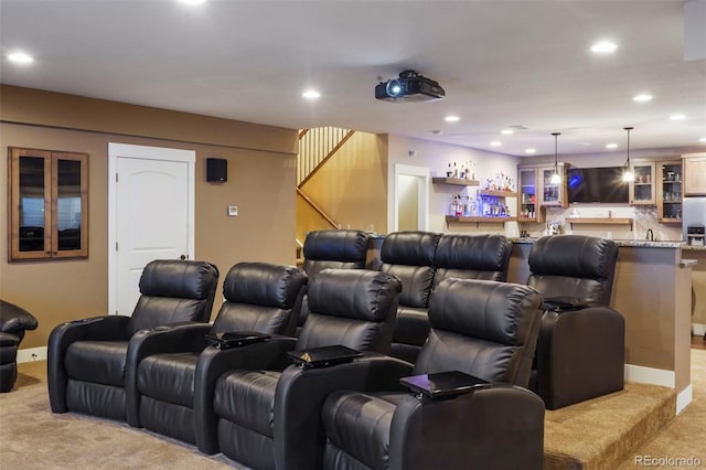 home theater room with light colored carpet and indoor bar