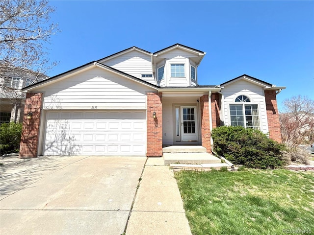 2835 S Tower Way, Aurora, CO 80013 - traditional-style house with brick siding, a garage, driveway, and a front lawn
