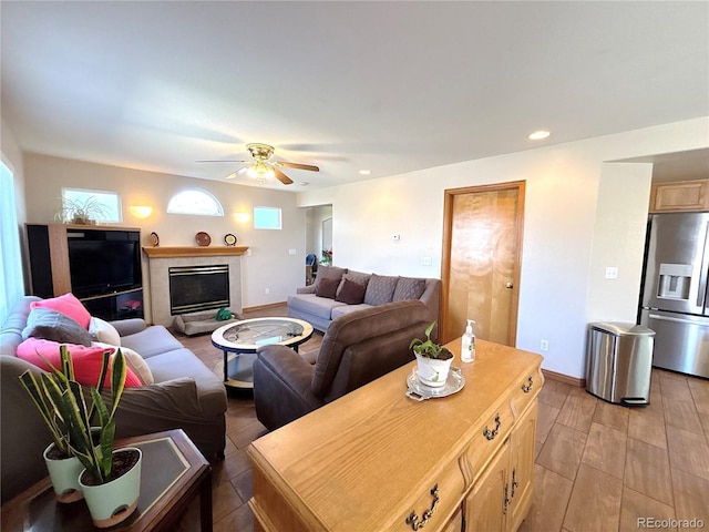 2835 S Tower Way, Aurora, CO 80013 - living room featuring a ceiling fan, a fireplace, light wood-type flooring, baseboards, and recessed lighting