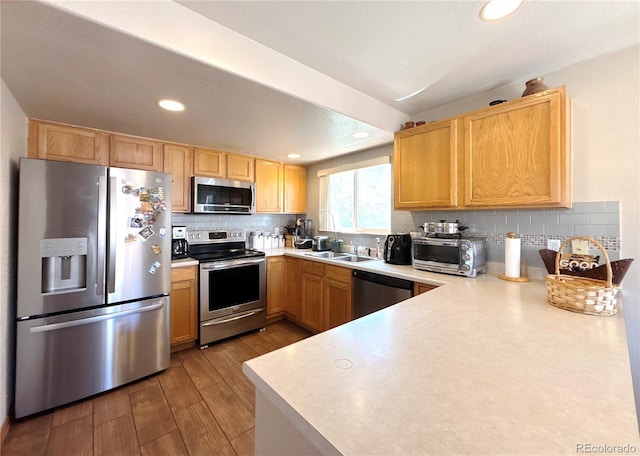 2835 S Tower Way, Aurora, CO 80013 - kitchen featuring stainless steel appliances, wood finished floors, decorative backsplash, light countertops, and recessed lighting