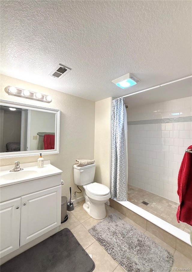 2835 S Tower Way, Aurora, CO 80013 - bathroom featuring vanity, a tile shower, toilet, a textured ceiling, and tile patterned flooring