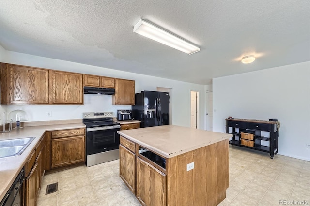 20530 Randolph Pl, Denver, CO 80249 - kitchen with black appliances, under cabinet range hood, a center island, a textured ceiling, and light flooring