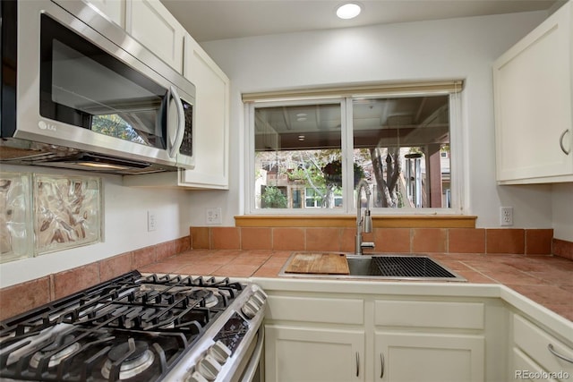 1460 Quince Ave Unit 102, Boulder, CO 80304 - kitchen featuring stainless steel appliances, tile counters, and white cabinetry