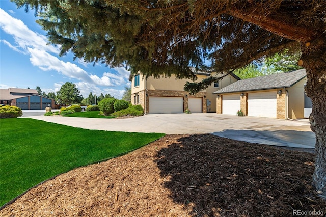 view of front of home with a garage, concrete driveway, a front lawn, and stucco siding