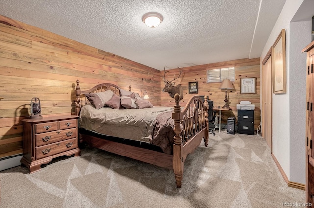 bedroom with carpet floors, wooden walls, and a textured ceiling