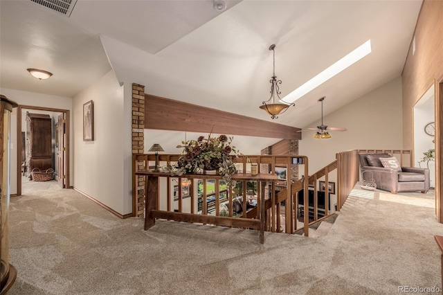 hallway featuring a skylight, carpet, visible vents, and an upstairs landing