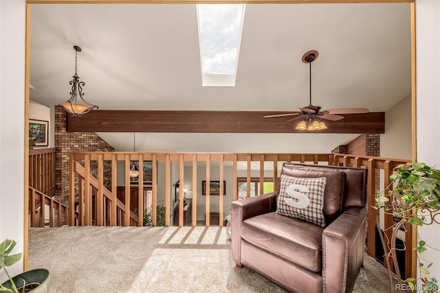 sitting room with vaulted ceiling with skylight, carpet flooring, and an upstairs landing