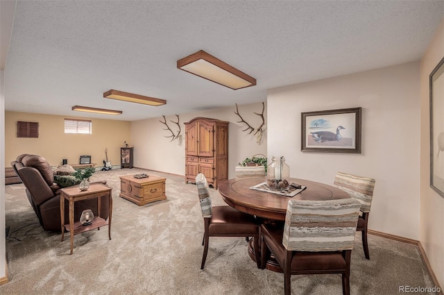 dining space featuring light carpet, a textured ceiling, visible vents, and baseboards