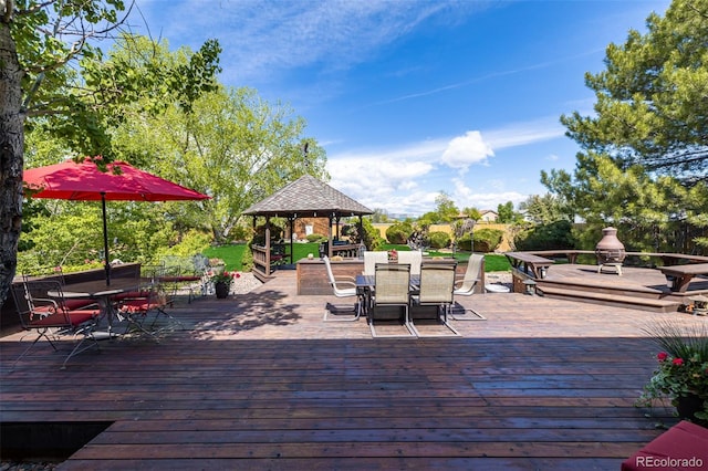 wooden deck featuring outdoor dining space and a gazebo