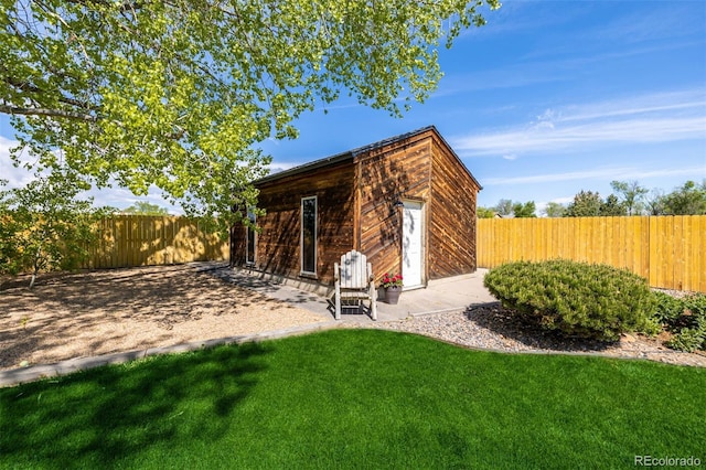 view of outbuilding with a fenced backyard and an outbuilding