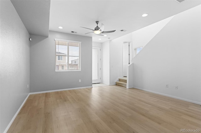 spare room featuring visible vents, light wood-style flooring, ceiling fan, baseboards, and stairs