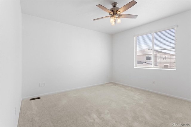 empty room with baseboards, ceiling fan, visible vents, and carpet flooring