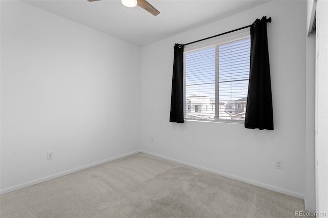 carpeted empty room with a ceiling fan and baseboards