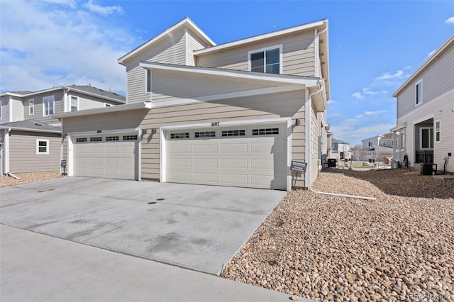 view of front of home with a garage, a residential view, and driveway