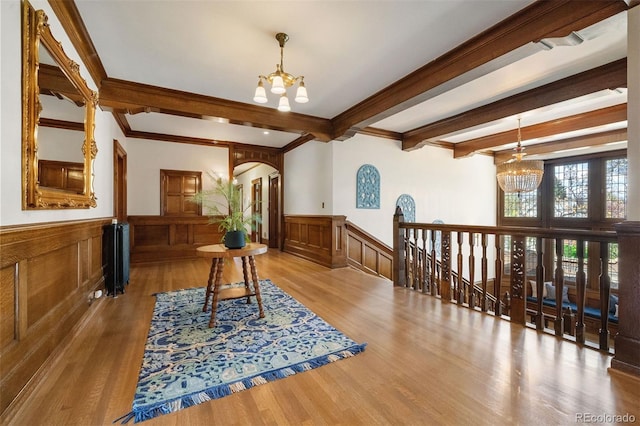 interior space featuring beam ceiling, a chandelier, and light wood-type flooring