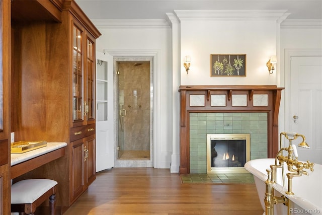 living room featuring crown molding, dark hardwood / wood-style flooring, and a tile fireplace