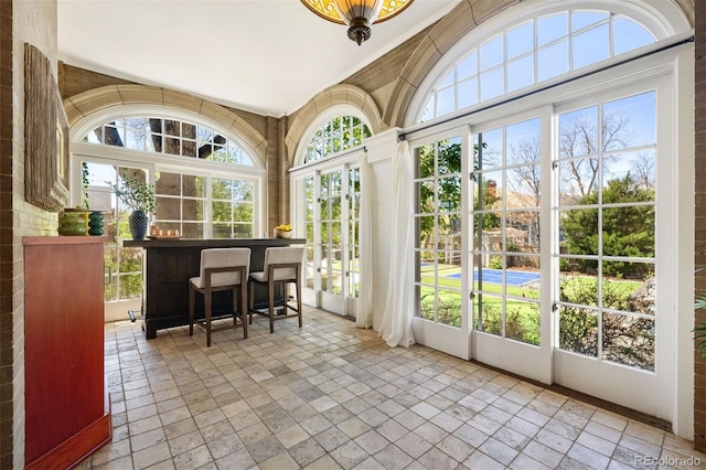 sunroom / solarium with plenty of natural light and bar area