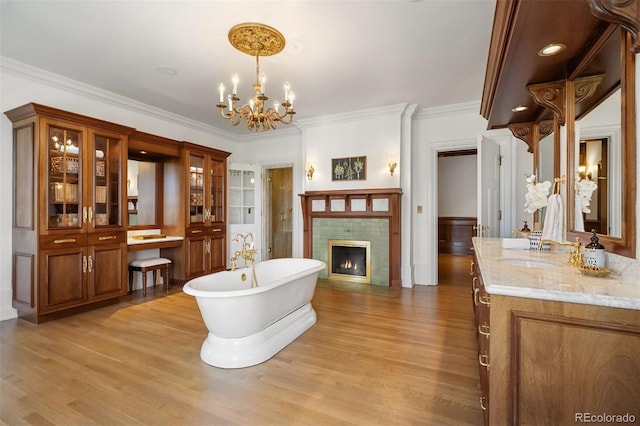 interior space featuring an inviting chandelier, sink, ornamental molding, and light wood-type flooring