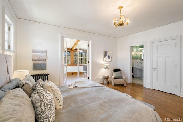 bedroom with an inviting chandelier, radiator, hardwood / wood-style flooring, and connected bathroom