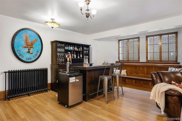 bar featuring radiator and light wood-type flooring