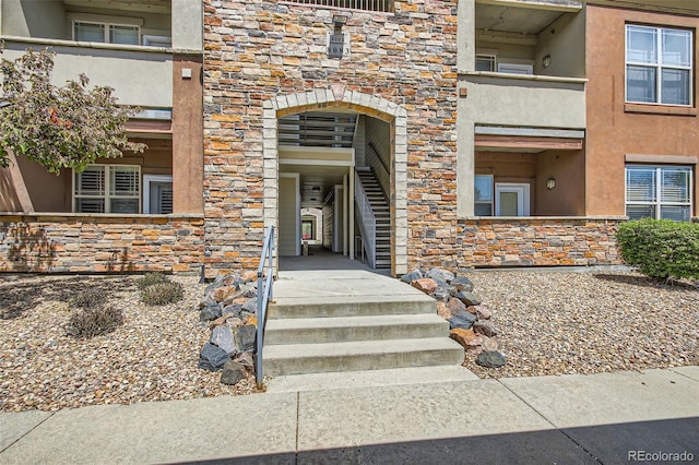 property entrance featuring stone siding and stucco siding