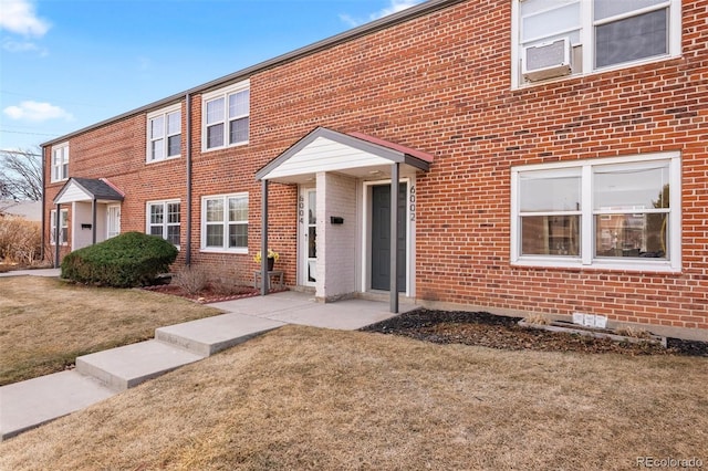 multi unit property featuring brick siding and a front lawn