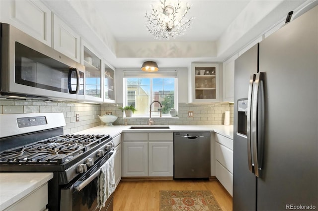 911 Laramie Blvd Unit B, Boulder, CO 80304 - kitchen featuring stainless steel appliances, light wood-style flooring, light countertops, glass insert cabinets, and white cabinetry
