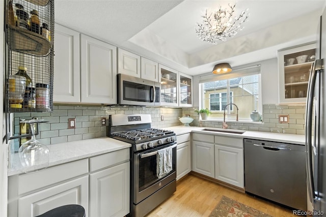 911 Laramie Blvd Unit B, Boulder, CO 80304 - kitchen featuring stainless steel appliances, light wood-style floors, white cabinets, and glass insert cabinets
