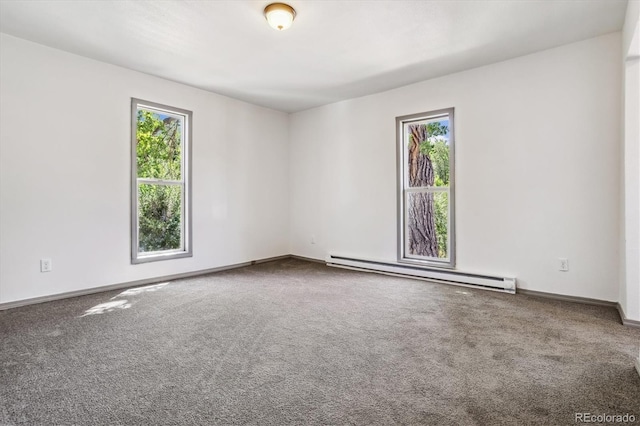 empty room featuring a wealth of natural light, carpet flooring, and a baseboard heating unit