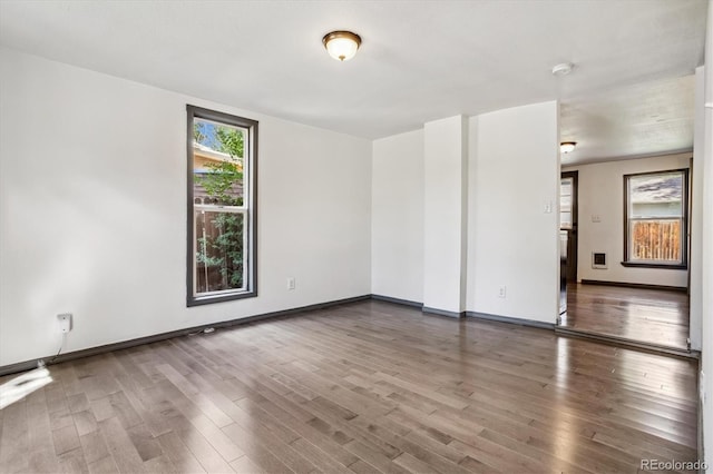 empty room with baseboards and wood finished floors