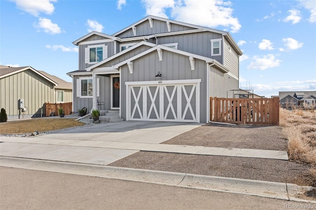 view of front of property featuring a garage, concrete driveway, board and batten siding, and fence